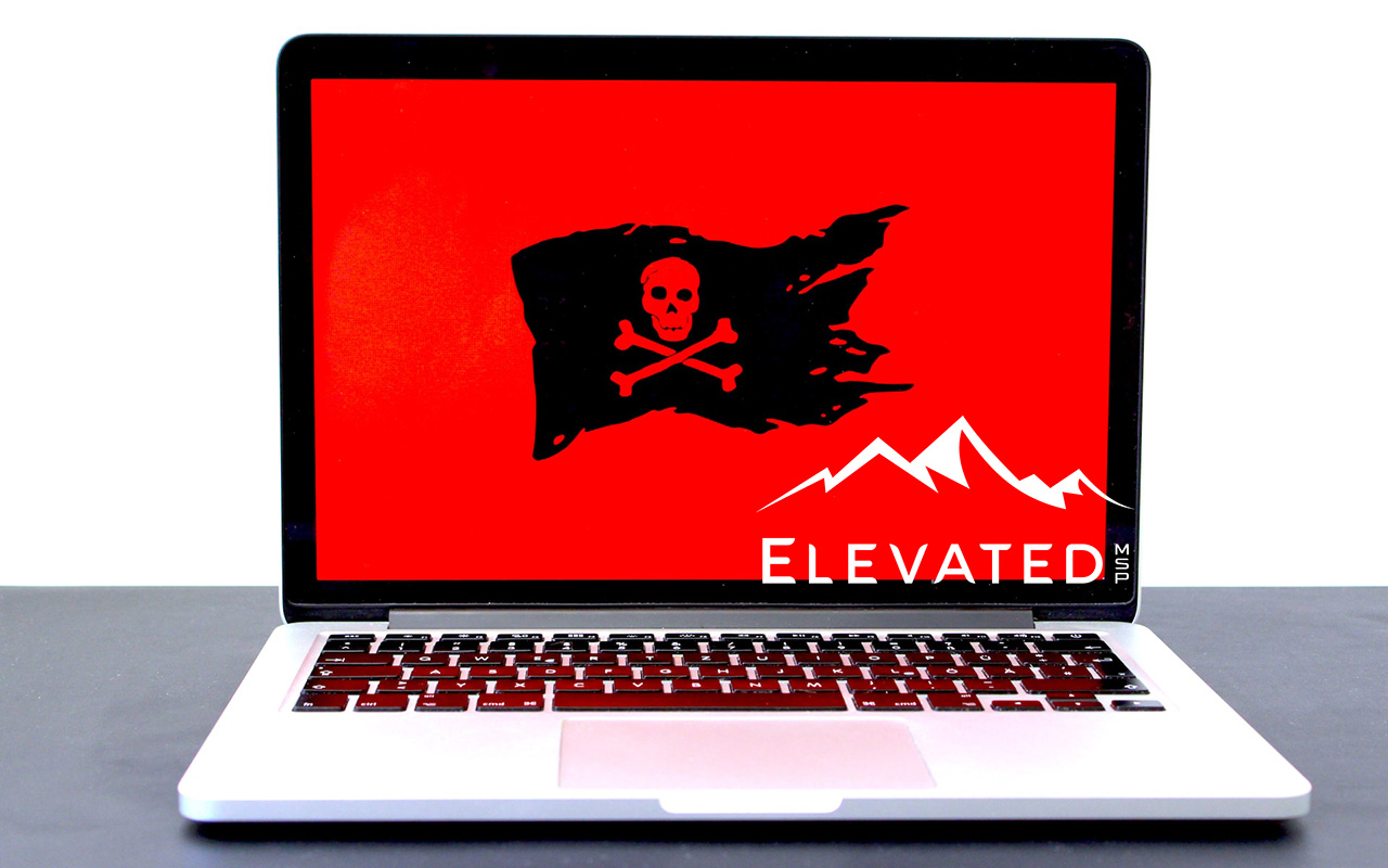 Apple laptop with lid open, screen showing a black pirate flag with a skull on a red background.